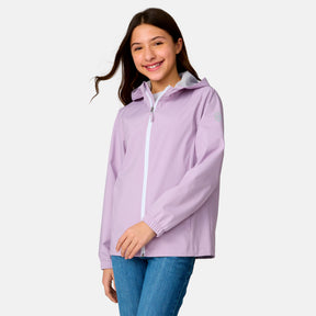 [Model is wearing a size Medium.] Girl wearing the Free Country Girls' Recess X2O Rain Jacket in Wisteria, size M, featuring lightweight stretch weatherproof fabric and a full length zipper and attached hood, paired with blue jeans #color_ wisteria