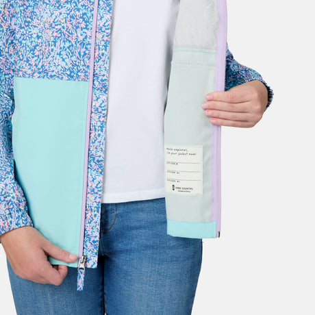 [Kai is wearing size 10-12 M] Child wearing a floral-patterned jacket with a light blue bottom half on a white background