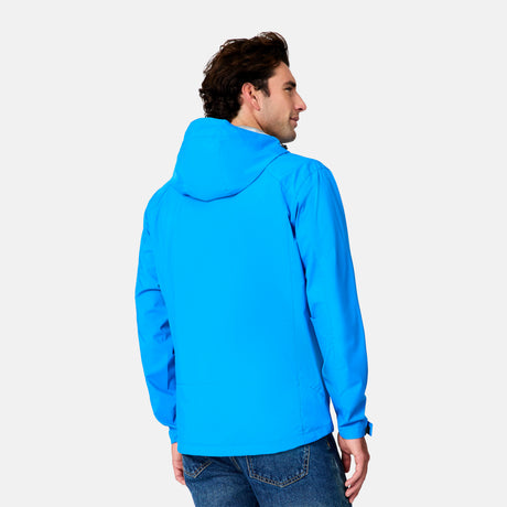 A man with dark hair, wearing the Free Country Men's Hydro Lite X2O Status Jacket and blue jeans, stands with his back to the camera against a plain white background.