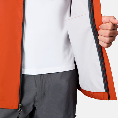 A person shows the white mesh inner pocket of the Free Country Men's Hydro Lite X2O Spectator Waterproof Jacket, wearing it over a white shirt and gray pants.