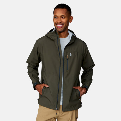 A man smiles with his hands in his pockets, wearing the Clearance Men's Hydro Lite X2O Highline Waterproof Jacket in olive green over a light gray shirt and tan pants, set against a plain light background.