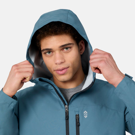 [Ikce is 6’1" wearing size M] Person wearing a blue rain jacket with a hood against a light gray background