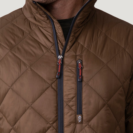 [Vince is 6'1" wearing a size Medium.] Man wearing the Free Country Men's Apex Quilted Puffer Jacket in brown, layered over a grey shirt and jeans, standing against a light background.