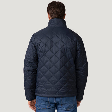 [Vince is 6'1" wearing a size Medium.] Man wearing the Free Country Men's Apex Quilted Puffer Jacket in navy, layered over a grey shirt and jeans, standing against a light background.