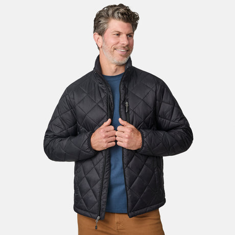[Kolby is 6'2" wearing size M] Model wearing a black quilted Free Country jacket with diamond-pattern stitching, high stand collar, and zippered chest pocket; paired with brown pants and a blue crewneck tee for a warm, transitional-weather look.