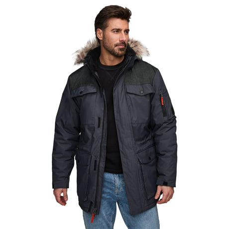 A man wearing a Clearance Men's Momentum II Midweight Parka Jacket with poly-fill insulation and detachable faux fur hood, black sweater, and blue jeans stands against a white background.