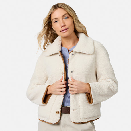 Cream faux shearling reversible jacket with brown trim worn by a model from the front