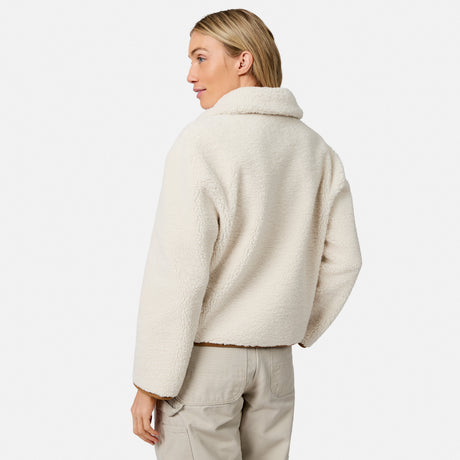 Profile of a model wearing a camel faux suede jacket with a plush white shearling collar