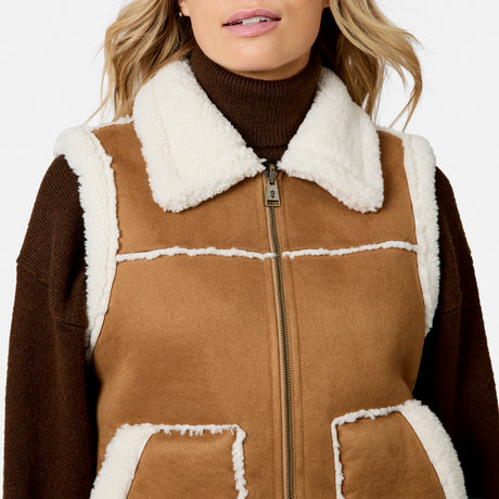 Close up of front zipper on tan brown faux suede shearling vest with white fleece trim