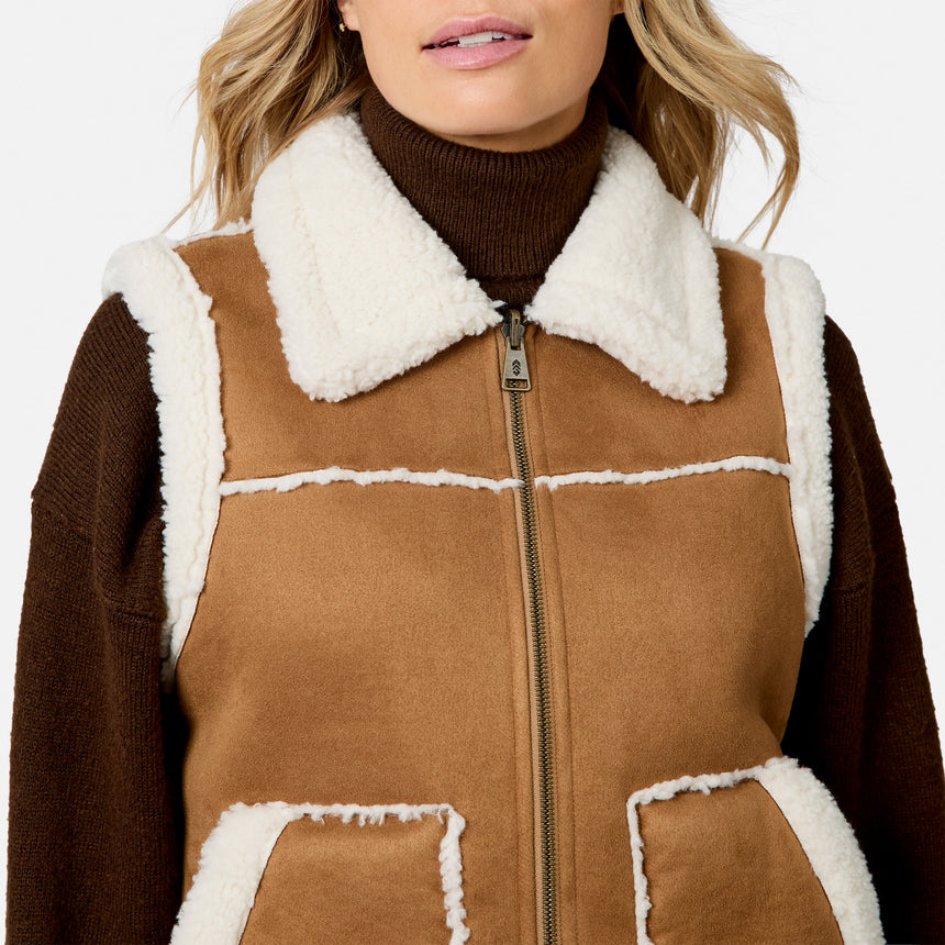 Close up of front zipper on tan brown faux suede shearling vest with white fleece trim