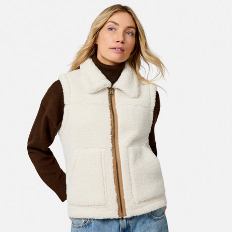 Model wearing ivory faux suede shearling reversible vest over a brown turtleneck