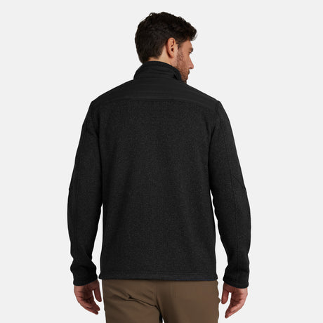 [Model is wearing size M.] Man wearing Free Country Men's Frore Knit Fleece Jacket in black with a full zip front, zipper chest pocket, light grey background. Perfect men’s jacket for fall weather.
