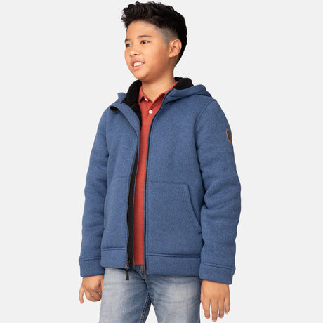 [Model is wearing a size Medium.] Boy wearing the Free Country Boys' Mountain Fleece Hoodie Jacket in blue, featuring a light grey zipper and small round logo on the sleeve.