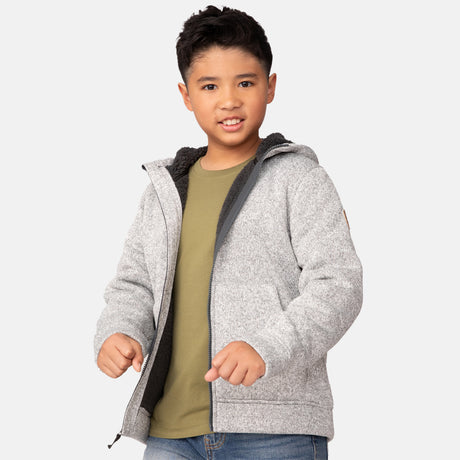 [Model is wearing a size Medium.] Boy wearing the Free Country Boys' Mountain Fleece Hoodie Jacket in light grey heather, featuring a light grey zipper and small round logo on the sleeve.
