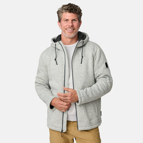 [Kolby is 6’2” wearing a size Medium.] Man wearing the Free Country Men's Northwood Mountain Fleece Hoodie in light gray with black drawstrings, standing with hands in pockets against a plain, light background.
