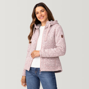 [Olga is 5’9" wearing a size Small.] Woman wearing Free Country Women's Mountain Fleece Jacket in pink with a full front zipper opening, soft lining, lower pockets, an attached hood with an adjustable drawcord, light grey background. Best women’s jacket for fall weather.
