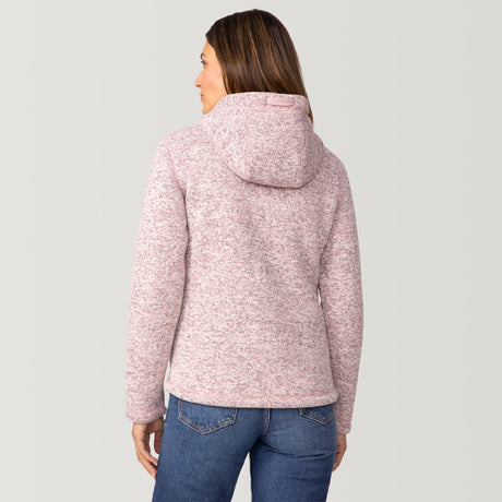 [Olga is 5’9" wearing a size Small.] Woman wearing Free Country Women's Mountain Fleece Jacket in pink with a full front zipper opening, soft lining, lower pockets, an attached hood with an adjustable drawcord, light grey background. Best women’s jacket for fall weather.
