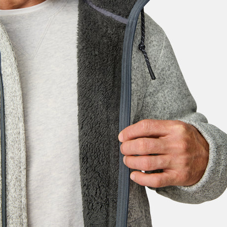 [Kolby is 6’2” wearing a size Medium.] Man wearing the Free Country Men's Northwood Mountain Fleece Hoodie in light gray with black drawstrings, standing with hands in pockets against a plain, light background.
