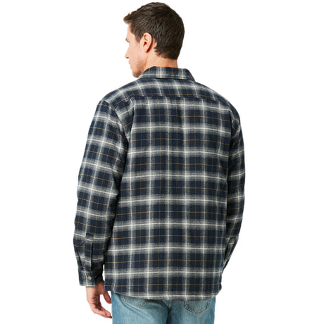 A man stands with his back to the camera, looking to the side in light blue jeans and a Clearance Men's FreeCycle® Utility Work Shirt—a blue and gray plaid flannel jacket made with eco-conscious REPREVE.