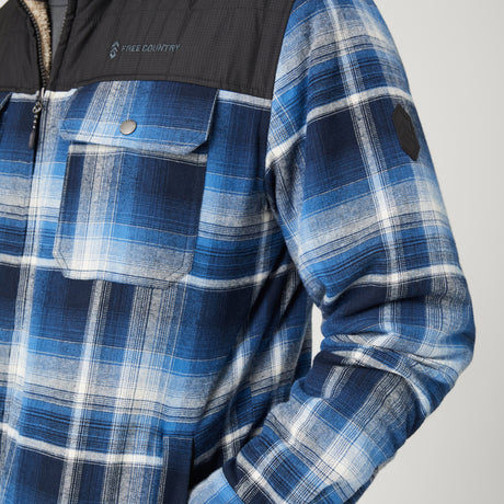 [Model is wearing a size Medium.] Man wearing Free Country Men's Woodsman Work Jacket in blue and white plaid with a full front zipper opening, soft lining, and recycled polyester filling, light grey background. Perfect men’s jacket for fall weather.