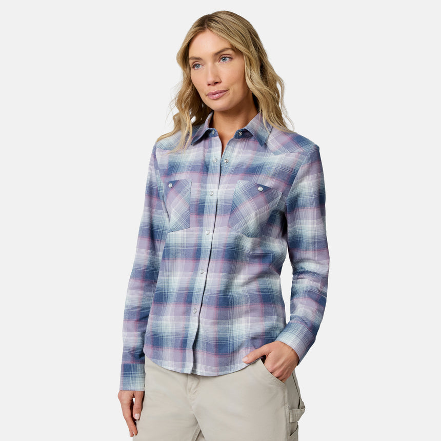 [Model is wearing size S.] A woman modeling a long-sleeve plaid button-up shirt in shades of blue, purple, and pink, paired with beige cargo pants, against a light gray studio background.
