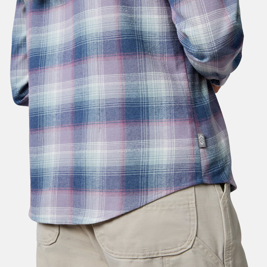[Model is wearing size S.] Close-up of a person wearing a long-sleeve plaid flannel shirt in blue, purple, and white, paired with beige cargo pants against a light gray studio background.