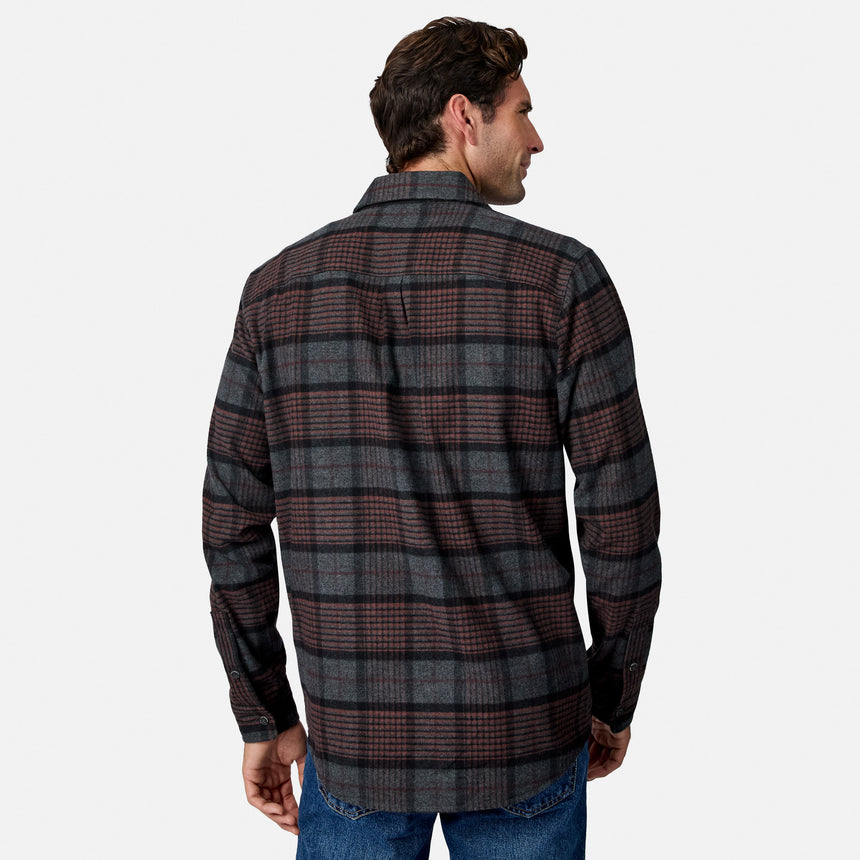 [Model is wearing size M.] A man viewed from the back wearing a long-sleeve plaid flannel shirt in dark gray, black, and muted red, paired with blue jeans, against a light gray studio background.