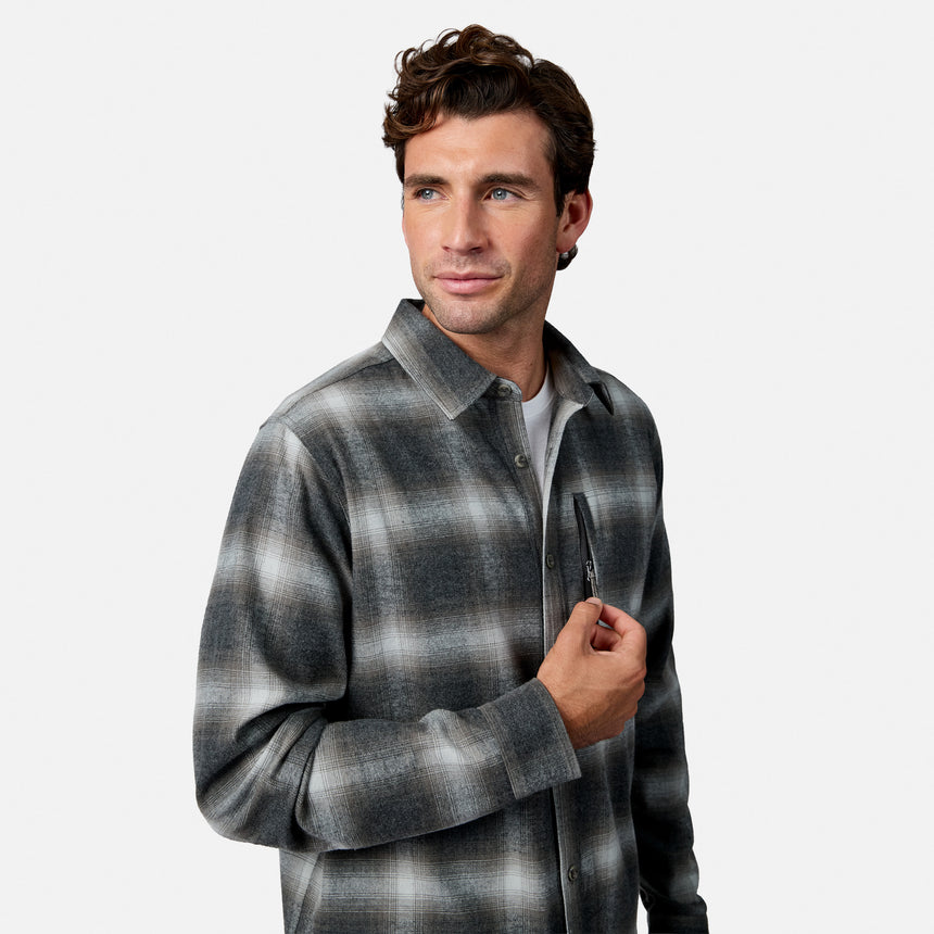 [Model is wearing size M.] A man wearing a charcoal gray and black plaid button-up shirt over a light gray t-shirt, posed against a solid light gray background.