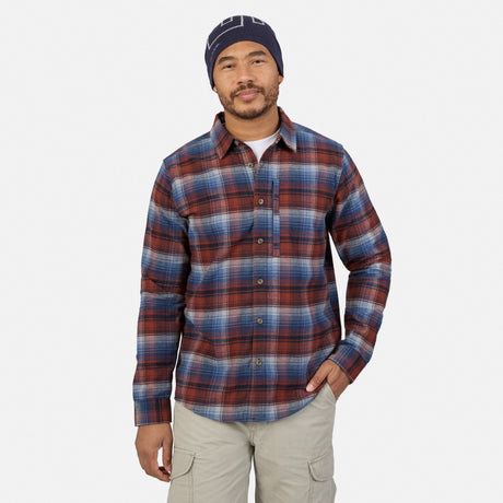 A man wearing a ruby plaid Men’s Easywear Flannel Shirt with a chest zipper pocket, khaki cargo shorts, and a navy blue beanie.