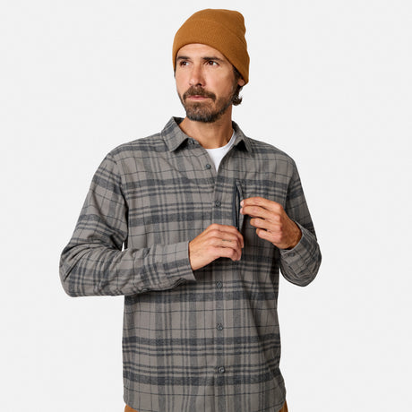 [Model is wearing size M.] A man wearing a gray and black plaid button-down shirt over a white undershirt, paired with a tan beanie, standing against a light gray studio background.