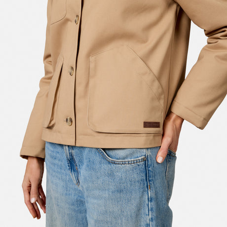 [Model is wearing size S.] A close-up of a person wearing a tan utility jacket with front flap pockets and blue jeans against a clean white background.