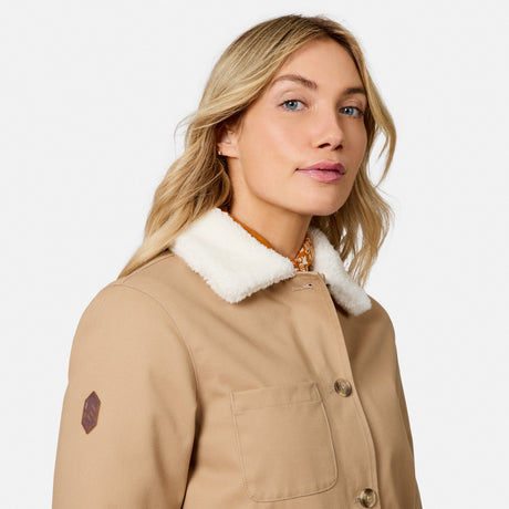 [Model is wearing size S.] A woman wearing a beige jacket with a white sherpa collar, shown in a close-up profile against a light gray studio background.