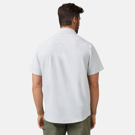 A man with short brown hair is seen from the back, wearing a Clearance Men's Expedition Nylon Rip-Stop Short Sleeve Shirt in light gray and olive green pants against a plain white background.