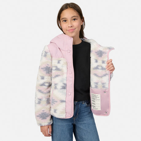 A girl modeling a hooded fleece jacket with a pink collar, hood, and front placket, paired with a black shirt and blue jeans against a light gray studio background.