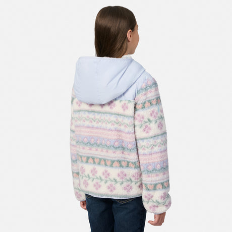 A child shown from the back wearing a fuzzy hooded jacket with a pastel Fair Isle pattern in pink, blue, and cream, paired with dark blue jeans against a light gray studio background.