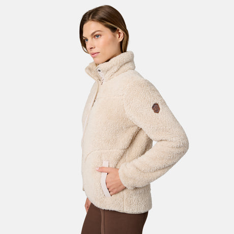 [Model is wearing size S.] A woman wearing a cream-colored sherpa fleece quarter-zip jacket with a high collar and a small brown logo patch on the upper sleeve, shown from a side profile against a light gray background.
