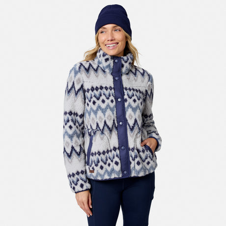 [Model is wearing size S.] A woman wearing a fuzzy high-collar button-front jacket with a blue, white, and gray geometric pattern, paired with a navy beanie and dark pants, against a light gray studio background.