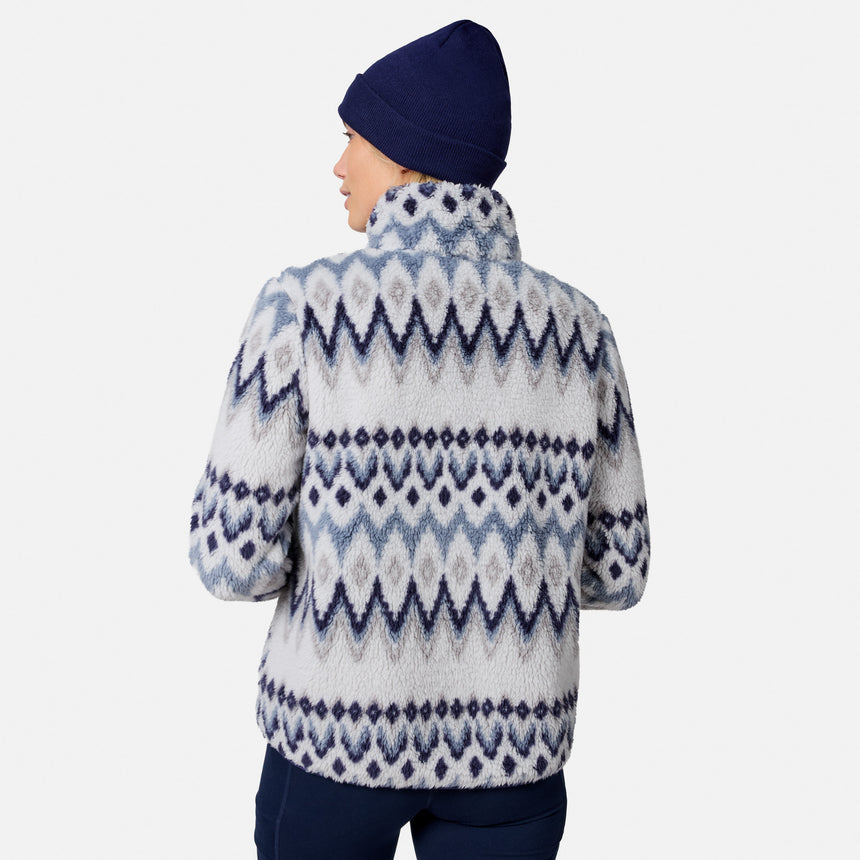 [Model is wearing size S.] A person shown from the back wearing a fuzzy knit mock-neck fleece jacket with a blue and white geometric pattern, paired with a navy beanie and navy pants, against a light gray studio background.