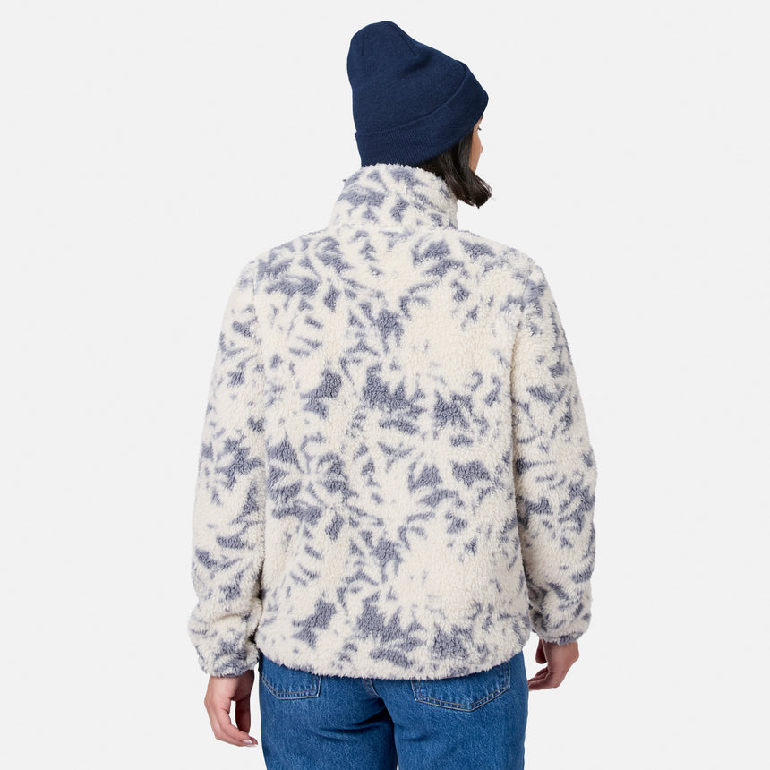 [Model is wearing size S.] A person shown from the back wearing a cream sherpa fleece jacket with a slate blue-gray abstract leaf-like pattern, a navy beanie, and blue jeans against a light gray studio background.
