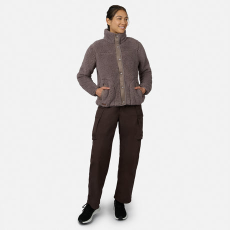 [Model is wearing size S.] A woman modeling a heathered taupe fleece button-up jacket with a high collar and side pockets, paired with dark brown cargo pants and black sneakers, against a light gray background.