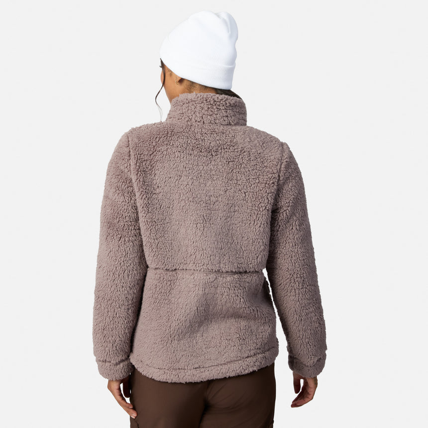 A person in a white beanie, Women’s Sierra Butter Pile® Zip Up Jacket by Free Country, and brown pants stands facing away against a plain white background.