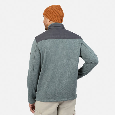 Back view of a person wearing a grey Men’s Frore Knit Fleece Jacket with a convertible collar, dark grey shoulder panels, and an orange beanie.
