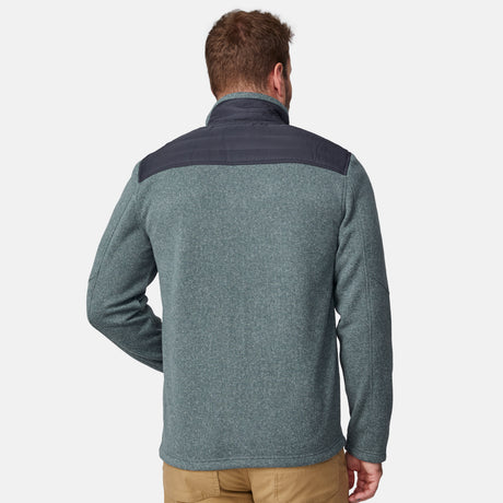 A man is seen from the back wearing the Free Country Men's Frore Knit Fleece Jacket, featuring a dark gray yoke and convertible collar, paired with tan pants against a plain white background.