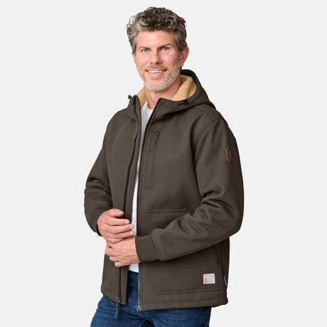 [Kolby is 6'2" wearing size M.] Men’s Free Country brown hooded jacket featuring full front zipper, two side pockets, and zippered chest pocket. Includes utility patch on left sleeve and subtle brand label at lower hem. Styled with blue jeans for a laid-back cold-weather look highlighting functional design and casual edge.