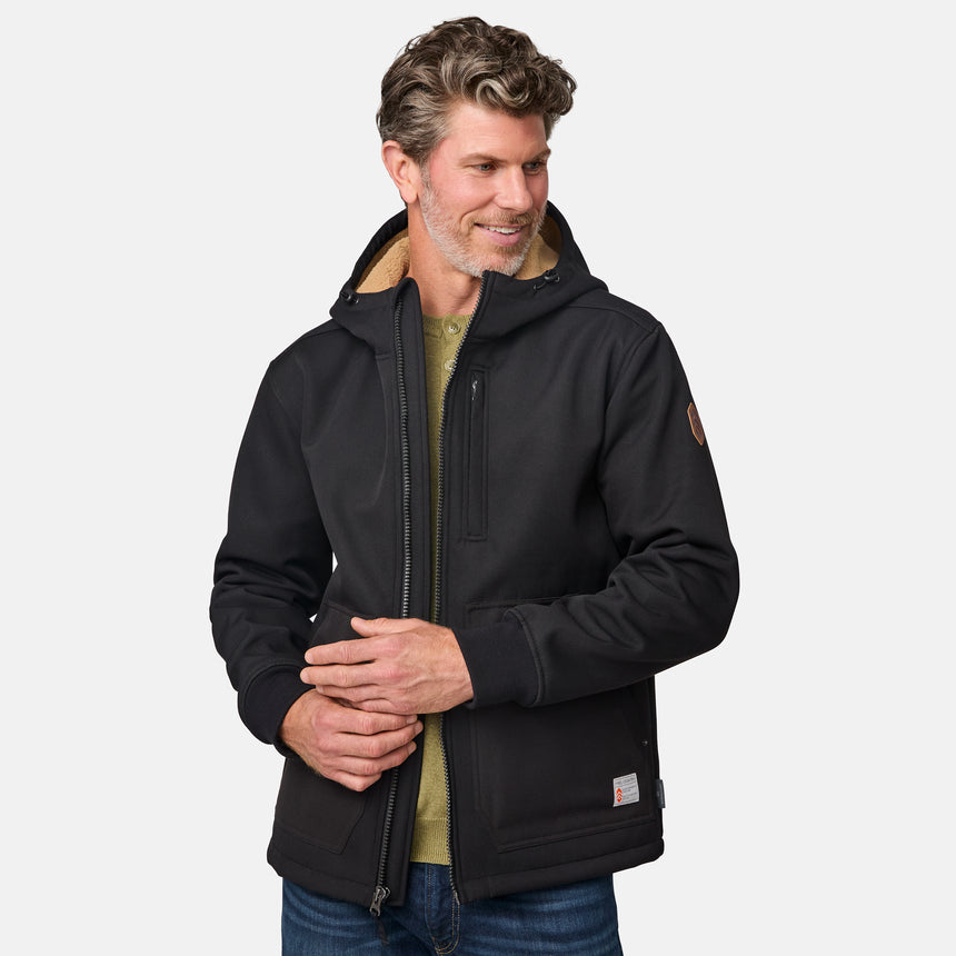 [Kolby is 6'2" wearing size M.] Men’s Free Country black hooded jacket featuring full front zipper, two side pockets, and zippered chest pocket. Includes utility patch on left sleeve and subtle brand label at lower hem. Styled with blue jeans for a laid-back cold-weather look highlighting functional design and casual edge.