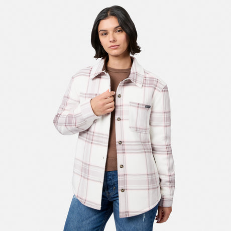 [Model is wearing size S.] A woman modeling a white long-sleeve plaid button-up shirt jacket with thin pink and gray lines, worn open over a brown t-shirt and blue jeans, against a light gray studio background.