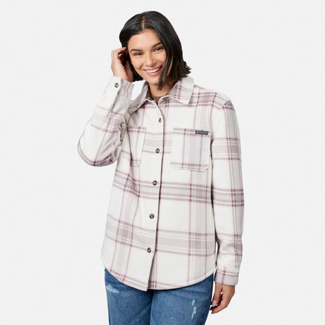 [Model is wearing size S.] A woman modeling a long-sleeve button-up flannel shirt with a cream base and a muted pink and brown plaid pattern, paired with blue jeans against a light gray studio background.