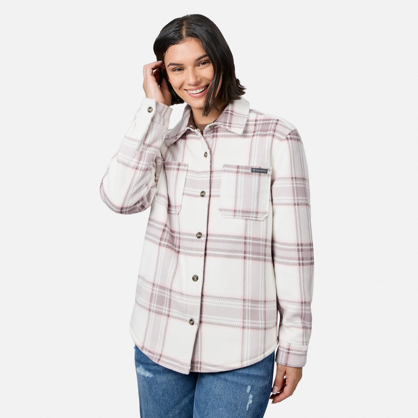 [Model is wearing size S.] A woman modeling a long-sleeve button-up flannel shirt with a cream base and a muted pink and brown plaid pattern, paired with blue jeans against a light gray studio background.