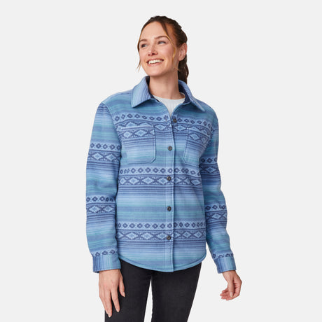 [Model is wearing size S.] A woman modeling a blue patterned button-up shirt jacket with a collar and chest pocket, paired with dark pants, against a light gray studio background.