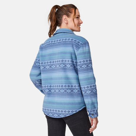[Model is wearing size S.] Back view of a woman wearing a blue patterned button-up shirt jacket over a white ribbed top and black jeans, photographed against a light gray studio background.